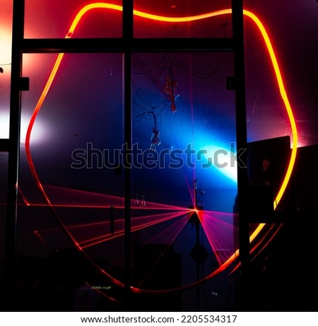 Light beam draws a weird red closed shape as red straight laser beams flash inside on the background striking fear and building up and intimidating environment. Futuristic room invoke terrors or awe Royalty-Free Stock Photo #2205534317