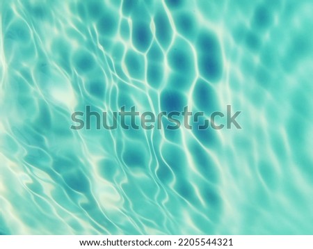 Closeup​ blur​ abstract​ of​ surface​ blue​ water. Abstrawct​ of​ surface​ blue​ water​ reflected​ with​ sunlight​ for​ background.Top​ view​ of blue​ water.​ Water​ splashed​ use​ for​ graphic art.