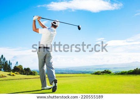Man Playing Golf on Beautiful Sunny Green Golf Course. Hitting Golf Ball down the Fairway from the Tee with Driver.  Royalty-Free Stock Photo #220555189