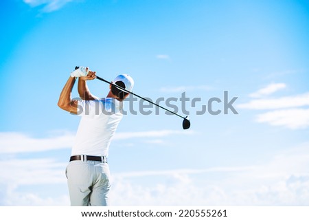 Man Swinging Golf Club with Blue Sky Background