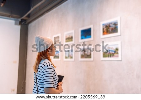 Woman visiting art gallery her looking pictures on wall watching photo frame painting at artwork museum people lifestyle concept. Royalty-Free Stock Photo #2205569139