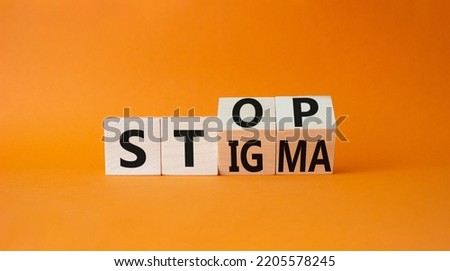 Stop and Stigma symbol. Businessman hand points at wooden cubes with words Stop and Stigma. Beautiful orange background. Business and Stop and Stigma concept. Copy space. Royalty-Free Stock Photo #2205578245