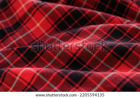Red tartan fabric, plaid cotton fabric. Textile background, close-up Royalty-Free Stock Photo #2205594135