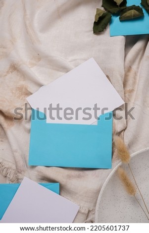 minimalist wedding card concept, white paper tucked in a light blue envelope. for wedding texture background. Top view.