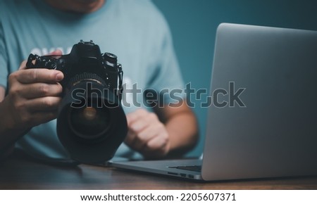 Young man learning to use and setting DSLR camera from video online course.