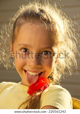 	cute school girl with tongue sticking out in sunny day