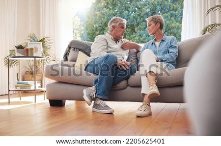Senior couple, serious talk and communication about problems and marriage issues while sitting on the sofa at home. Mature man and woman talking and discussing issues, trouble and divorce Royalty-Free Stock Photo #2205625401