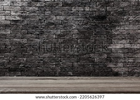 Blank wood table old black brick background.
Empty wooden desk with dark gray wall building construction. 
Studio display your products template.