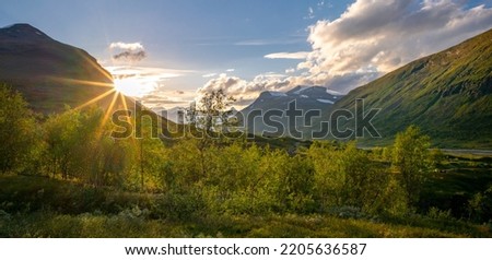 Sun setting behind the mountain in remote Arctic valley. Sarek National Park, Lapland, Sweden. Sun star. Hiking in remote wilderness of Laponia. Sunset in the mountains. Royalty-Free Stock Photo #2205636587
