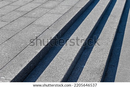 Gray steps of gray paving slabs. Gray concrete or stone stairs steps background. Abstract stairs, abstract steps, city stairs. Light and shadow on the stone steps. Black and white photography,diagonal