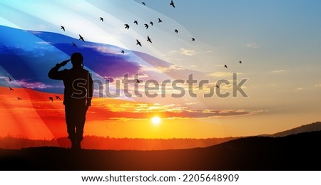 Silhouette of russian soldier in uniforms on background of sunset sky with the Russian flag. Military recruitment concept. Royalty-Free Stock Photo #2205648909
