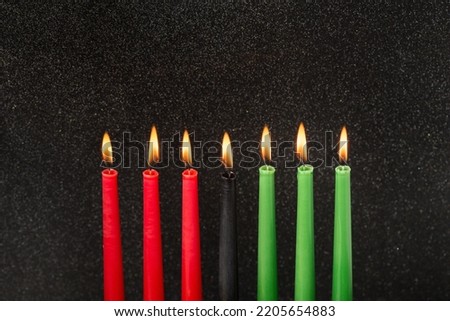 Kwanzaa festival concept with seven candles red, black and green on black background, copy space