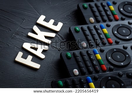 fake the word in front of him remotes to the TV in one row. fake tv programs and management