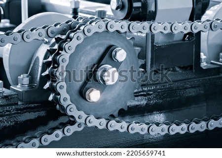Gear chain drive shaft in conveyor belt is on production line. Timing chain of car, tensioners in engine. Industrial roller chain, technology. Team work, business industrial concept Royalty-Free Stock Photo #2205659741