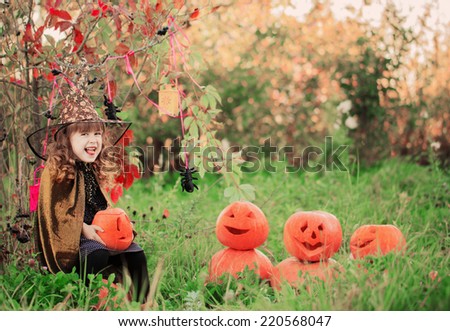 happy girl in halloween costume with jack pumpkin