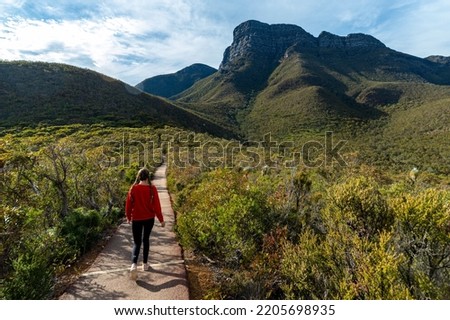 girl with pigtails begins ascent of huge mountain, highest peak in western australia Royalty-Free Stock Photo #2205698935