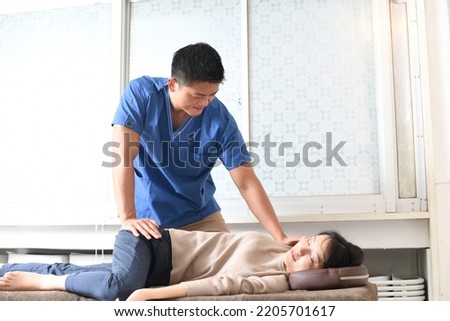 Male chiropractor and female patient who perform chiropractic massage Royalty-Free Stock Photo #2205701617