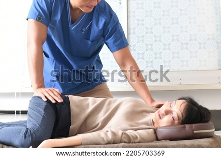 Male chiropractor and female patient who perform chiropractic massage Royalty-Free Stock Photo #2205703369