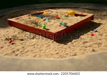 Children's playground with sand. Children's sandbox on street. Place for game kids. Sand with toys. Forgotten toys. Royalty-Free Stock Photo #2205706603