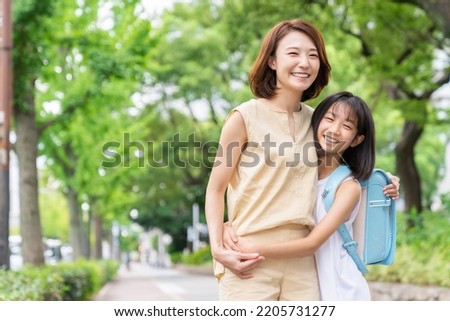 young asian mother and daughter , School bag