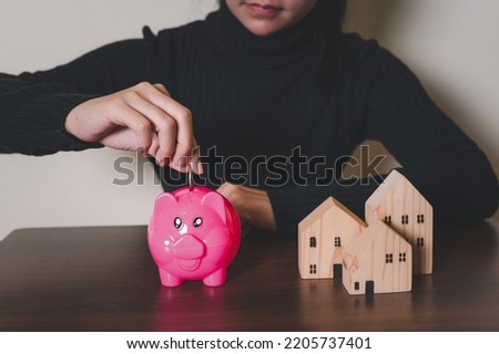Household savings and finances, Smiling Woman putting coin in piggy bank. Saving money concept