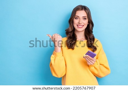 Closeup photo of young adorable gorgeous cute woman hold phone finger pointing empty space recommend offer eshopping isoalated on blue color background