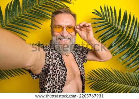 Photo portrait of nice granddad video recording tropical jungle dressed stylish leopard print outfit isolated on yellow color background