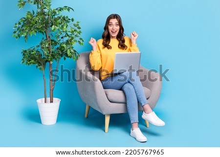 Full length photo of sweet lucky lady wear yellow sweater working modern gadget sitting chair isolated blue color background Royalty-Free Stock Photo #2205767965