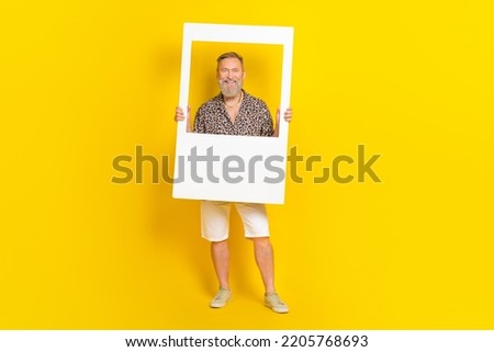 Photo of nice grandparent hold instant photo frame photo session dressed stylish leopard print look isolated on yellow color background