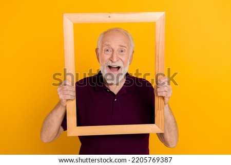 Photo of excited senior man have fun make picture creative face reaction isolated over yellow color background