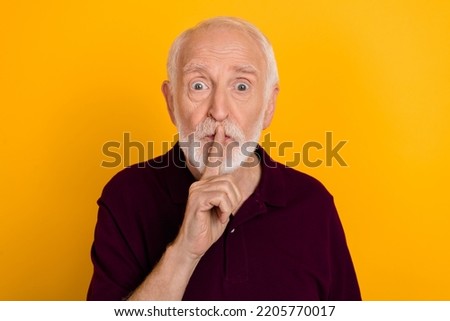 Photo of mature man cover lips finger keep secret gossip confidential isolated over yellow color background