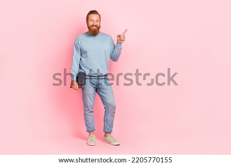 Full length portrait of positive handsome guy direct finger empty space isolated on pink color background