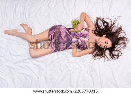 Top above high angle view of attractive dreamy girl lying in soft cosy bed holding flowers bunch 8 March day on white linen Royalty-Free Stock Photo #2205770313