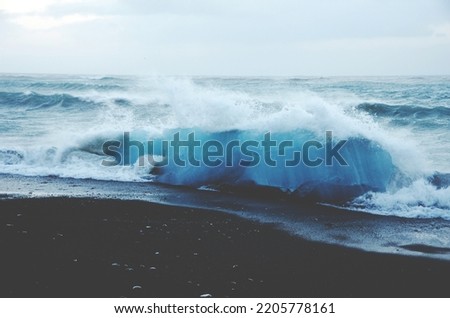 Tall sea waves splashing against an empty beach