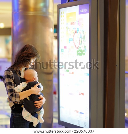 Young woman with her little baby in a shopping mall