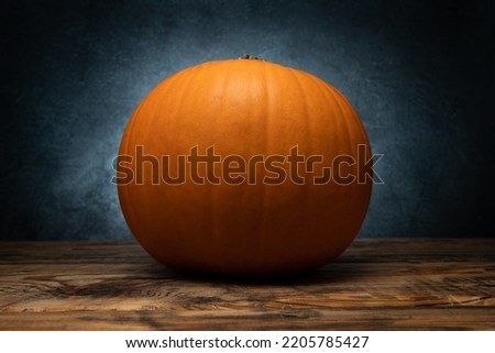 Orange pumpkin with stem cut off, autumn or fall still life.