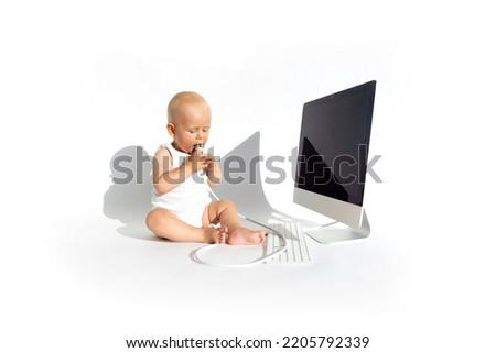 Cute baby playing with laptop computer isolated on white background. Copy space. Early childhood education concept. Children cartoon addiction.