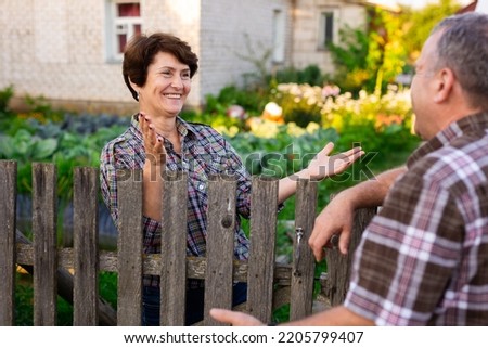 neighbors man and woman chatting near the Royalty-Free Stock Photo #2205799407