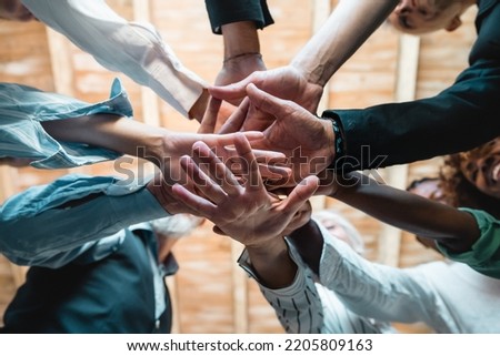Group of businesspeople joining hands together standing in circle, closeup view from bottom - Creative business teamwork building concept - soft skills project Royalty-Free Stock Photo #2205809163