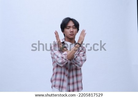 asian young man demonstrating something to stop on a white background

