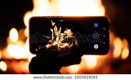 Shooting on the phone. A smartphone on a tripod shoots fire.