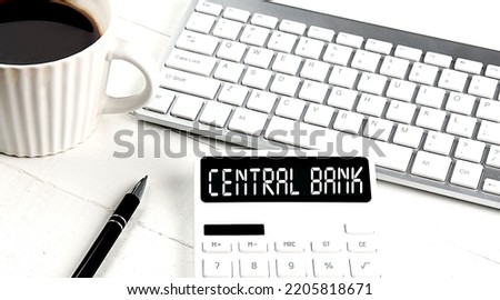 CENTRAL BANK text on a calculator with keyboard and coffee