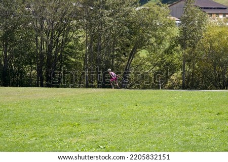 Woman exercising with roller skates and sticks at mountain village Oberwald, Canton Valais, on a sunny late summer day. Photo taken September 12th, 2022, Obergoms, Switzerland.