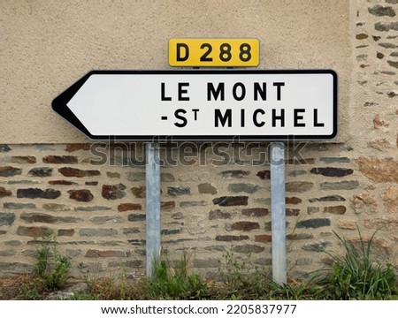 road sign with the text Le Mont ST Michel and the arrow to reach the Normadian abbey in France