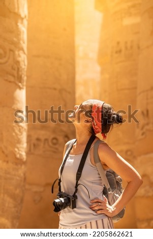 Tourist looking up to columns with hieroglyphs in a temple