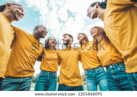 Multi ethnic young people team hugging together outside - International community of students support and help each other - Friendship, team building and diversity concept Royalty-Free Stock Photo #2205868095