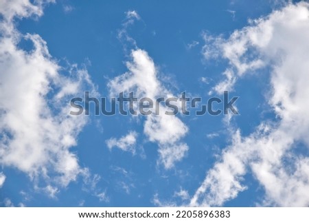 Beautiful cloudy sky. Blue sky with lots of white cumulus clouds, natural background, full frame. Copy space, place for text. Selective focus.