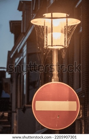 old lamp with traffic sign in the night