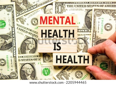 Mental health psychological symbol. Concept words Mental health is health on wooden blocks on a beautiful background from dollar bills. Psychologist hand. Psychological mental health concept.