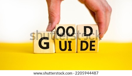Good guide symbol. Concept words Good guide on wooden cubes. Businessman hand. Beautiful yellow table white background. Good guide and business concept. Copy space.